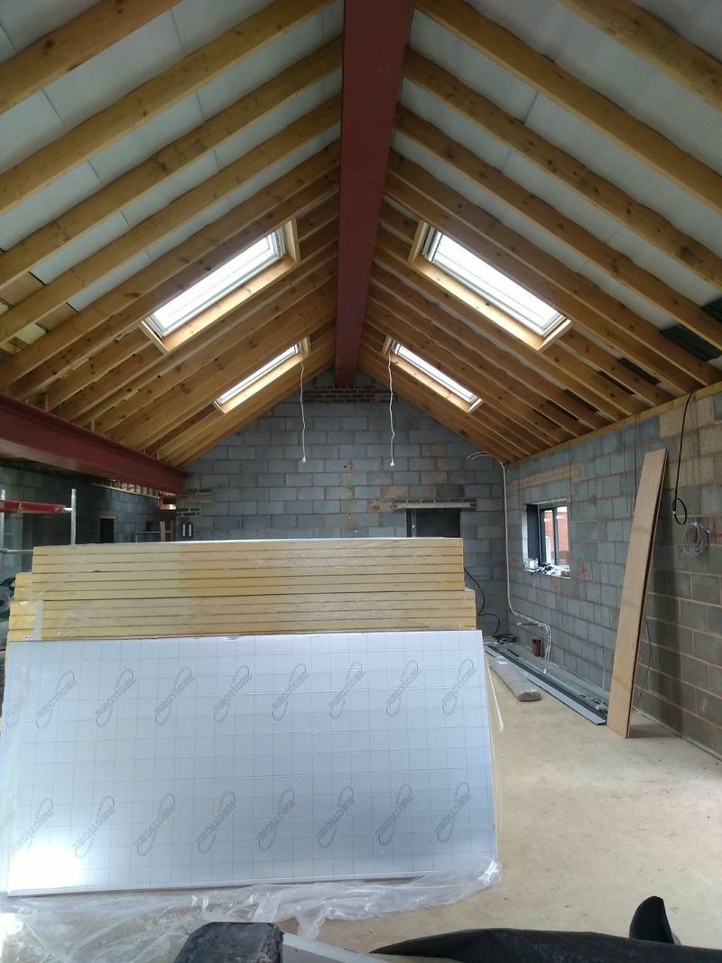 Extension roof with timber rafters, roof windows and insulation boards ready to fit