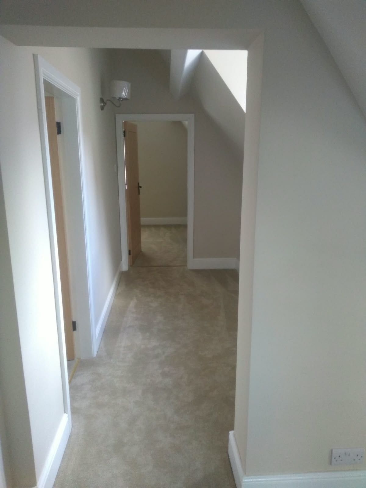 Finished landing with freshly painted walls, white doors and new carpet